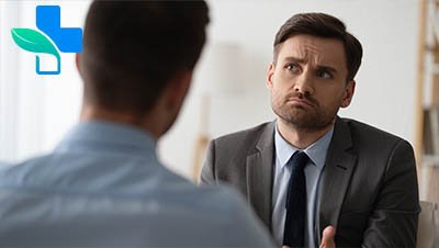 Мужчина сидит в кресле, призадумавшись разговаривает с собеседником